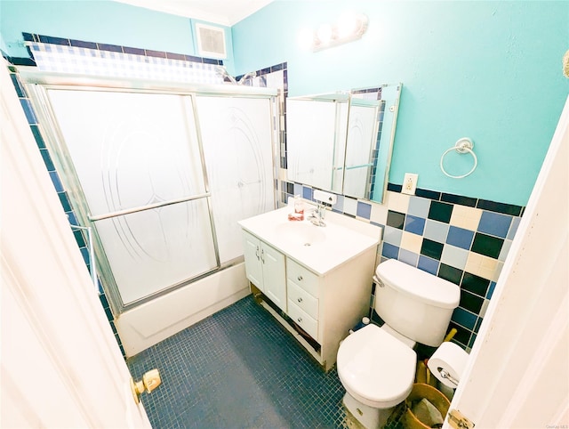 full bathroom with tile patterned floors, vanity, tile walls, and combined bath / shower with glass door