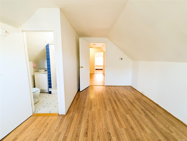 bonus room with light hardwood / wood-style floors and lofted ceiling