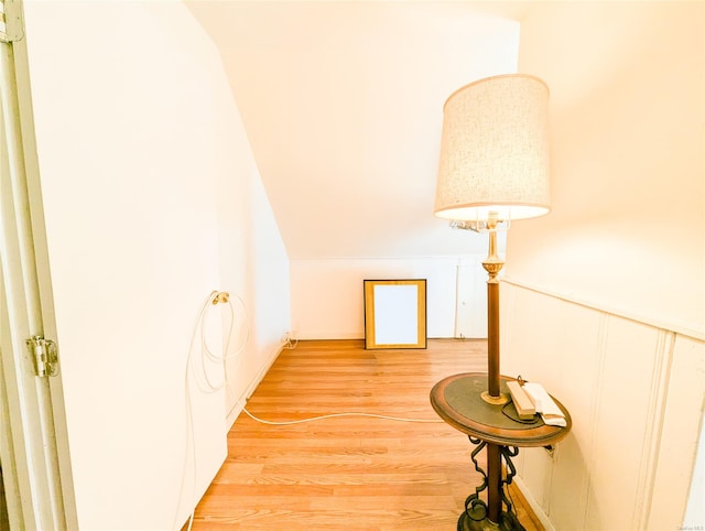 hallway with hardwood / wood-style flooring and lofted ceiling