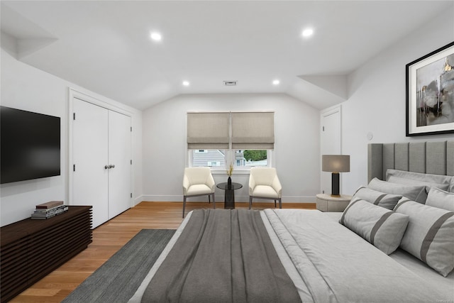 bedroom featuring vaulted ceiling, a closet, and light wood-type flooring