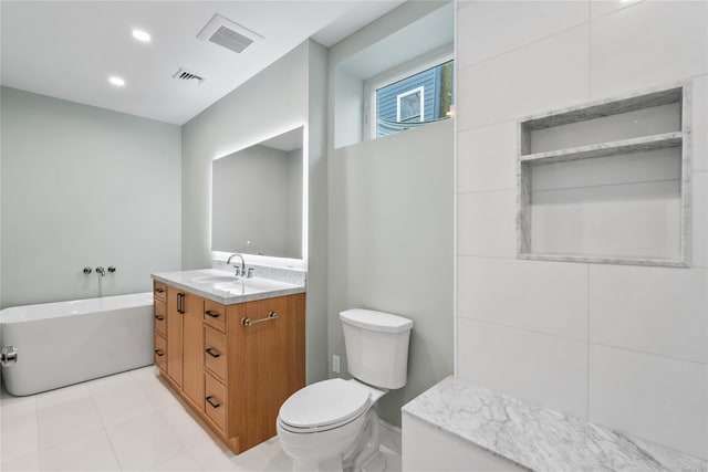 bathroom featuring a tub to relax in, vanity, and toilet