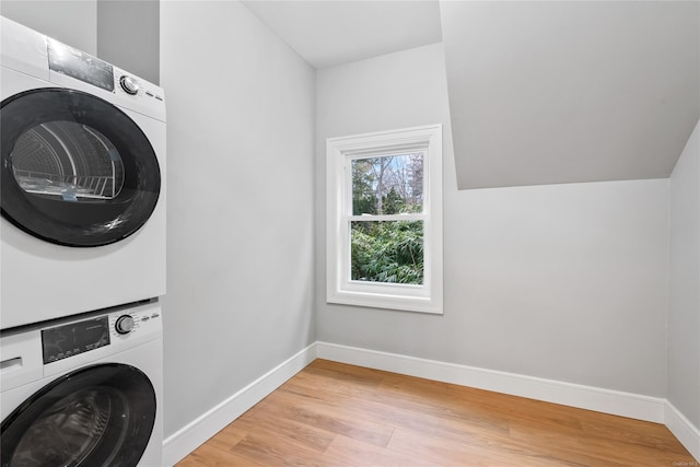 clothes washing area with stacked washer and dryer and light hardwood / wood-style flooring