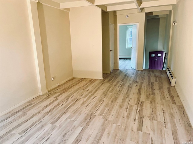 spare room featuring light hardwood / wood-style floors, beam ceiling, and a baseboard radiator