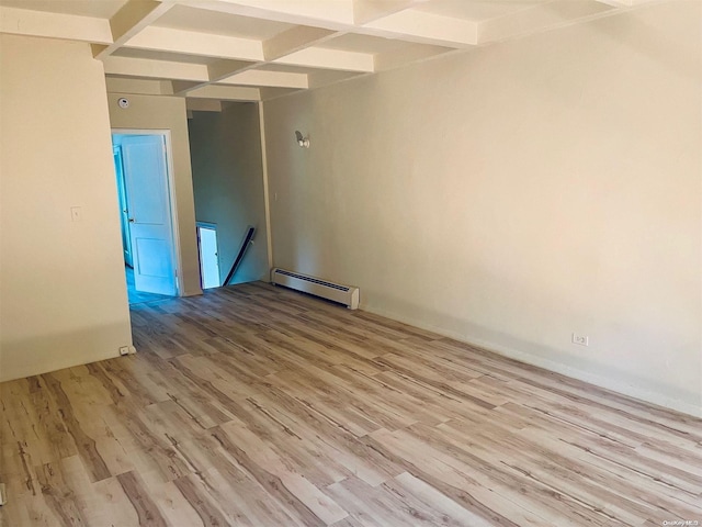 spare room with light hardwood / wood-style floors, beam ceiling, and a baseboard heating unit