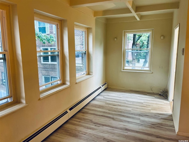 unfurnished room with beam ceiling, light wood-type flooring, baseboard heating, and plenty of natural light