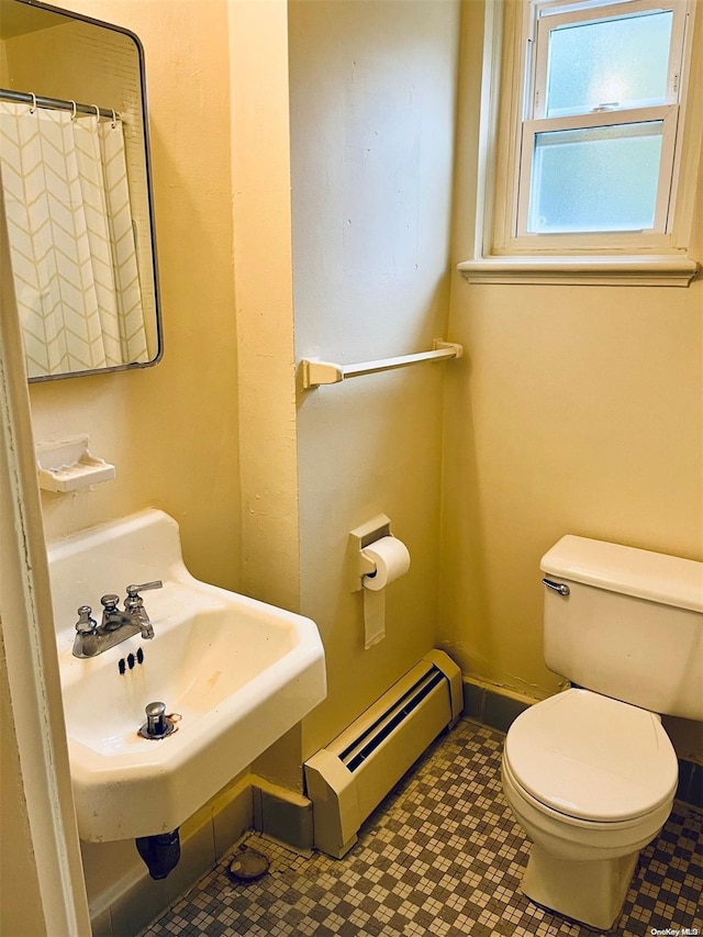 bathroom with toilet, sink, and a baseboard radiator