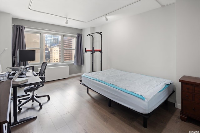 bedroom with track lighting and light wood-type flooring