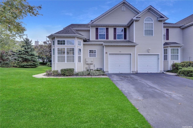 front of property with a garage and a front lawn