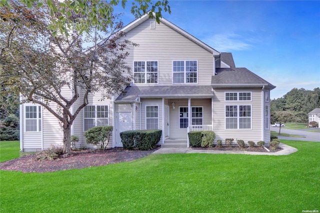 view of property featuring covered porch and a front yard