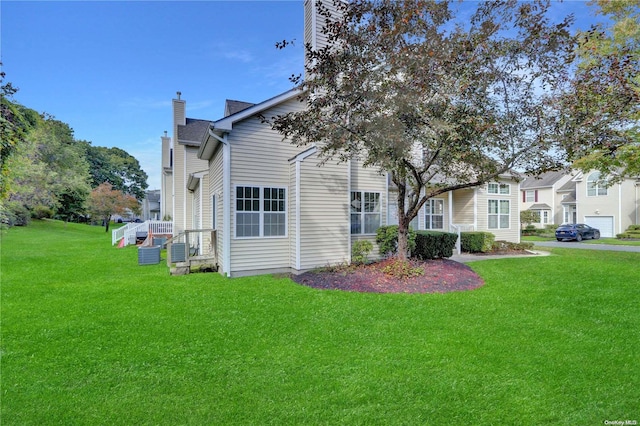 view of home's exterior with cooling unit and a lawn