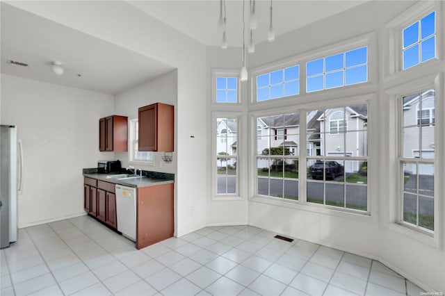 kitchen with stainless steel fridge, dishwasher, and light tile patterned floors