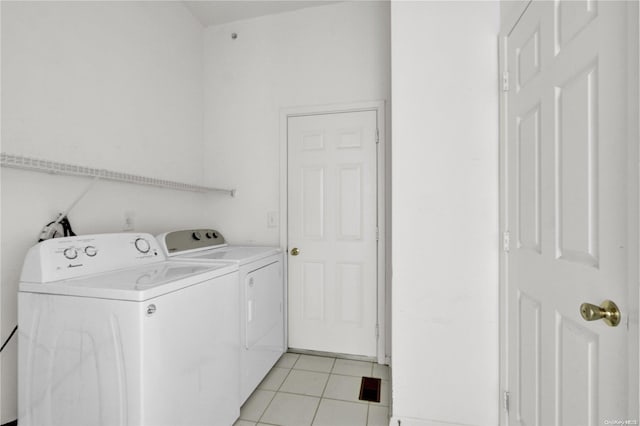 clothes washing area featuring light tile patterned flooring and washing machine and clothes dryer