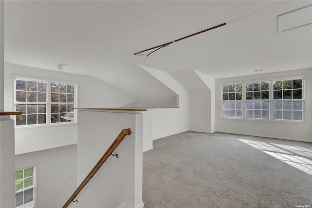 bonus room with a wealth of natural light, light colored carpet, and lofted ceiling