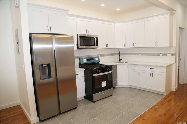 kitchen featuring light wood-type flooring, white cabinetry, and stainless steel appliances