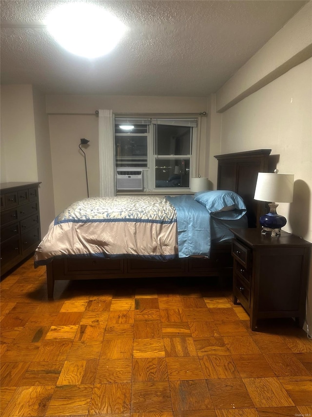 bedroom with a textured ceiling and dark parquet flooring