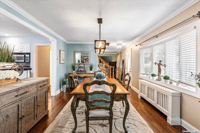 dining space with dark hardwood / wood-style flooring and ornamental molding