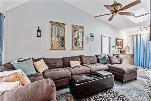 living room with lofted ceiling with skylight and ceiling fan