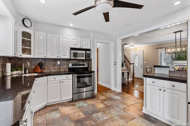 kitchen featuring white cabinetry, sink, stainless steel appliances, backsplash, and pendant lighting