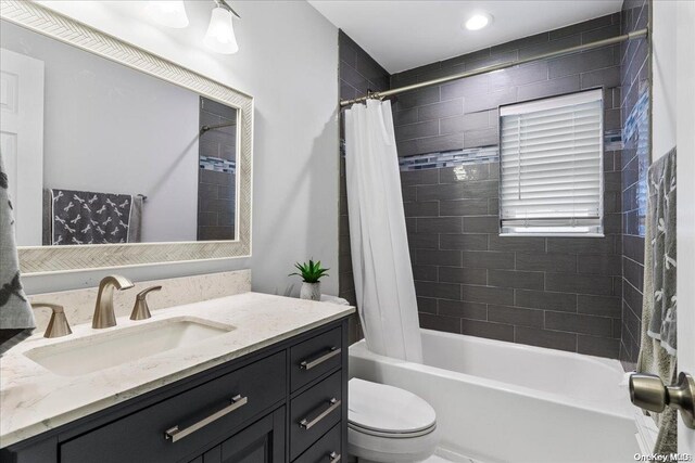 full bathroom with shower / bath combo with shower curtain, vanity, and toilet