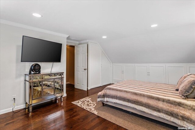 bedroom featuring dark wood-type flooring, lofted ceiling, and ornamental molding