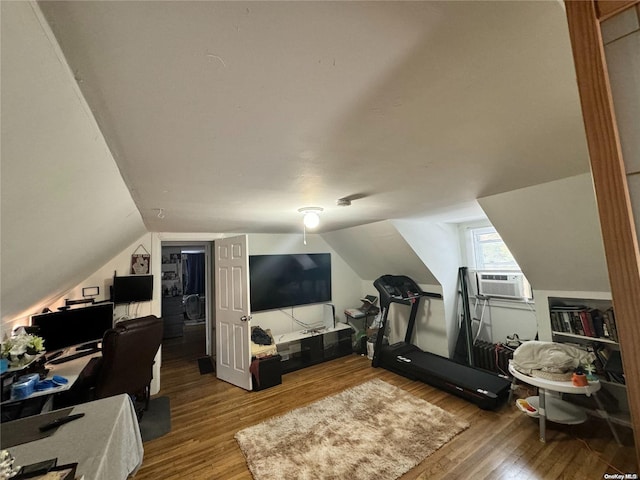 workout room with wood-type flooring, vaulted ceiling, and cooling unit