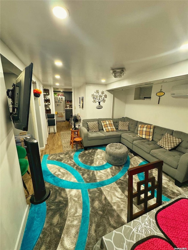 living room featuring a wall mounted air conditioner and wood-type flooring