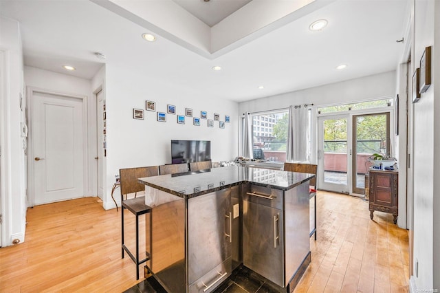 kitchen featuring a breakfast bar, light hardwood / wood-style floors, and a kitchen island