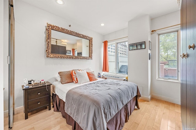 bedroom with light hardwood / wood-style flooring and multiple windows