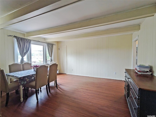 dining room with beamed ceiling, baseboards, and wood finished floors