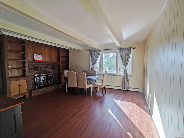 dining area featuring beamed ceiling, a brick fireplace, wood finished floors, and a baseboard radiator