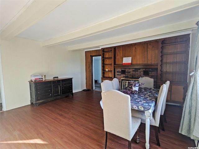 dining area with a fireplace, beam ceiling, and wood finished floors