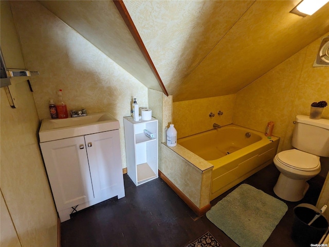 bathroom featuring vanity, wood finished floors, lofted ceiling, a garden tub, and toilet