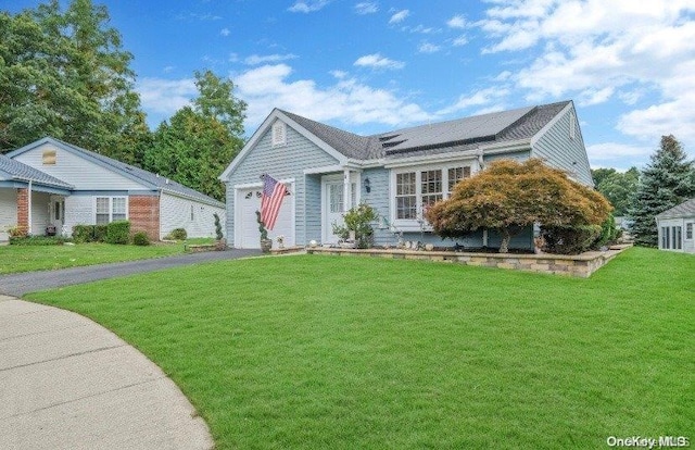 view of front of house featuring solar panels, a garage, and a front lawn