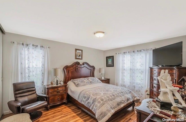 bedroom with light wood-type flooring and multiple windows