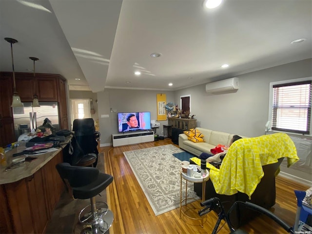 living room featuring wood-type flooring, crown molding, and a wall unit AC