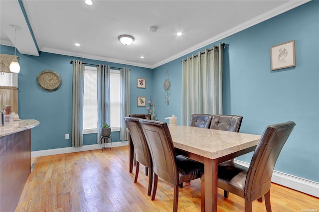 dining space with light hardwood / wood-style flooring and ornamental molding