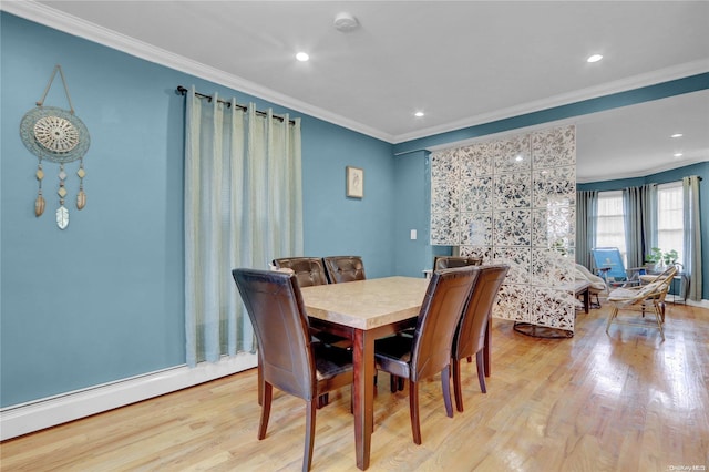 dining room featuring baseboard heating, light hardwood / wood-style floors, and ornamental molding