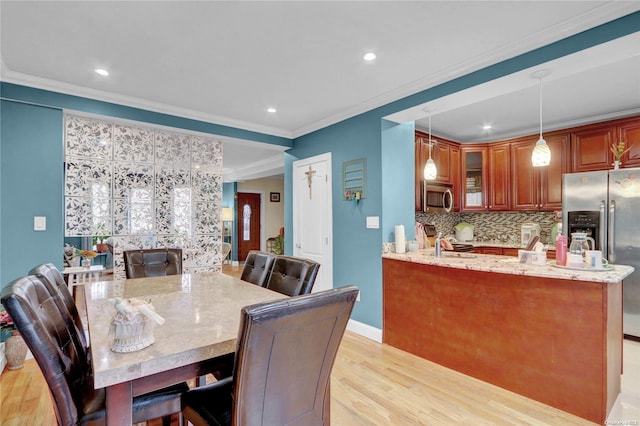 dining space featuring light hardwood / wood-style floors and ornamental molding