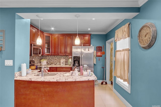 kitchen with kitchen peninsula, tasteful backsplash, stainless steel appliances, sink, and decorative light fixtures