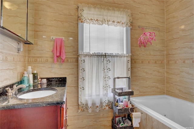 bathroom with vanity and tiled bath