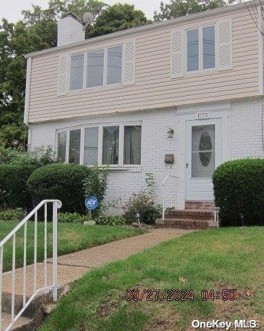 111 President St, Hempstead, NY 11550 - colonial inspired home with entry steps, a chimney, and a front lawn
