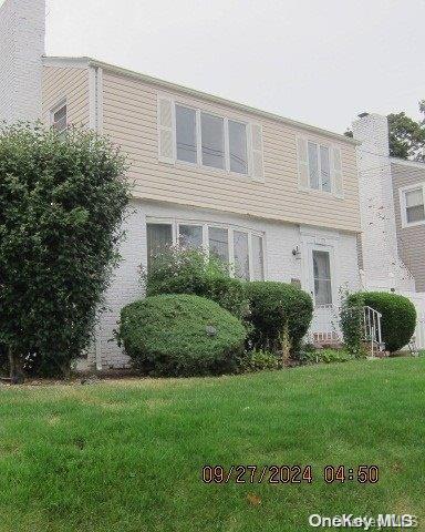 111 President St, Hempstead, NY 11550 - view of front of property with a front lawn and a chimney
