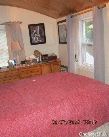 bedroom featuring lofted ceiling and wooden ceiling