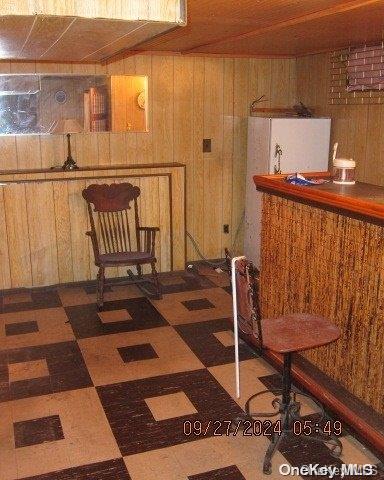 111 President St, Hempstead, NY 11550 - dining space with wood walls, tile patterned floors, wooden ceiling, and a bar