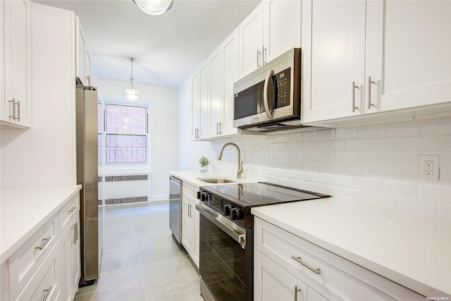 kitchen featuring white cabinets, radiator heating unit, stainless steel appliances, and sink