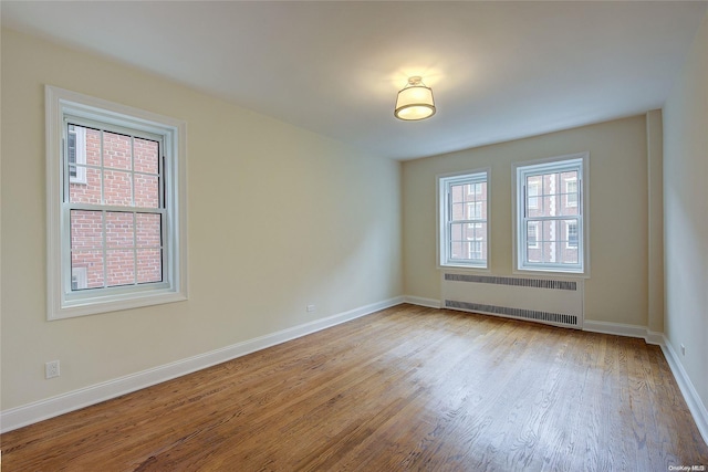 spare room with light hardwood / wood-style floors and radiator