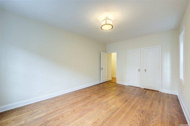 unfurnished bedroom with light hardwood / wood-style flooring and a closet