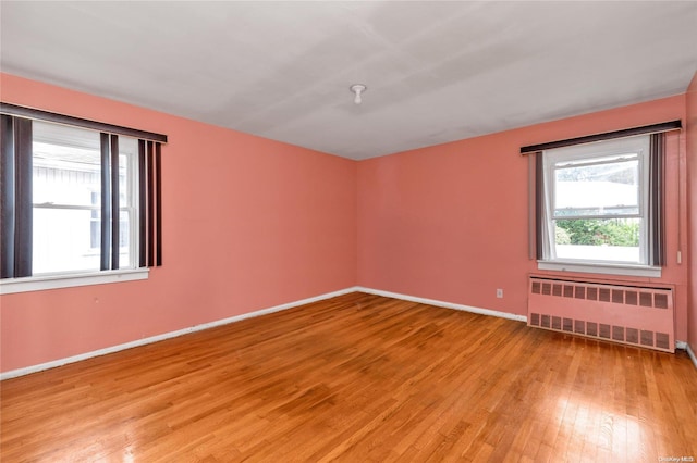 spare room with light wood-type flooring and radiator