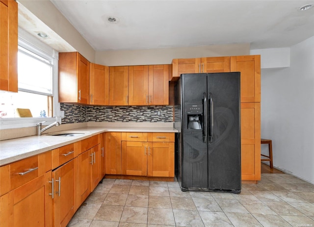 kitchen with decorative backsplash, light tile patterned floors, black refrigerator with ice dispenser, and sink