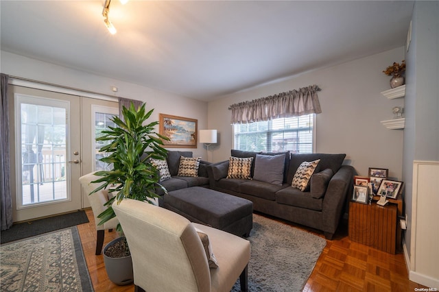 living room featuring french doors, dark parquet floors, and a healthy amount of sunlight